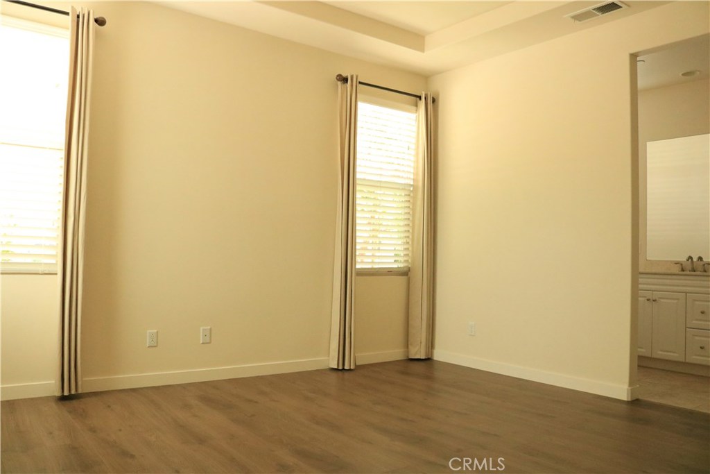 100 Desert Bloom Irvine, CA 92618 - Photo 5 of 15 a view of an empty room with wooden floor and a window