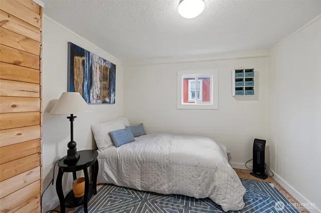 a view of a hallway with wooden floor and a bathroom