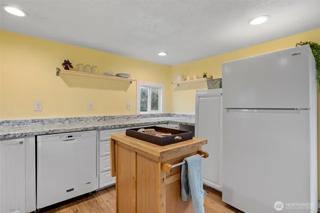 a kitchen with stainless steel appliances granite countertop a refrigerator and a sink