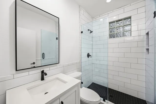 a bathroom with a sink a toilet and shower