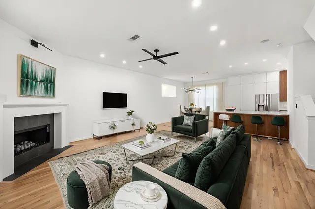 a living room with furniture kitchen view and a fireplace