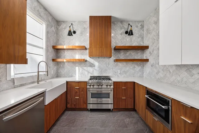 a kitchen with stainless steel appliances a stove a sink and a microwave