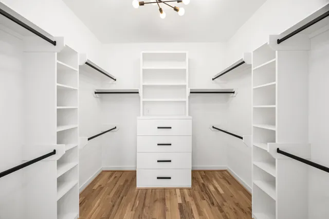 a view of walk in closet with empty racks