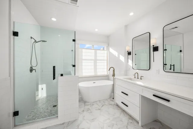 a spacious bathroom with a double vanity sink a mirror and a shower