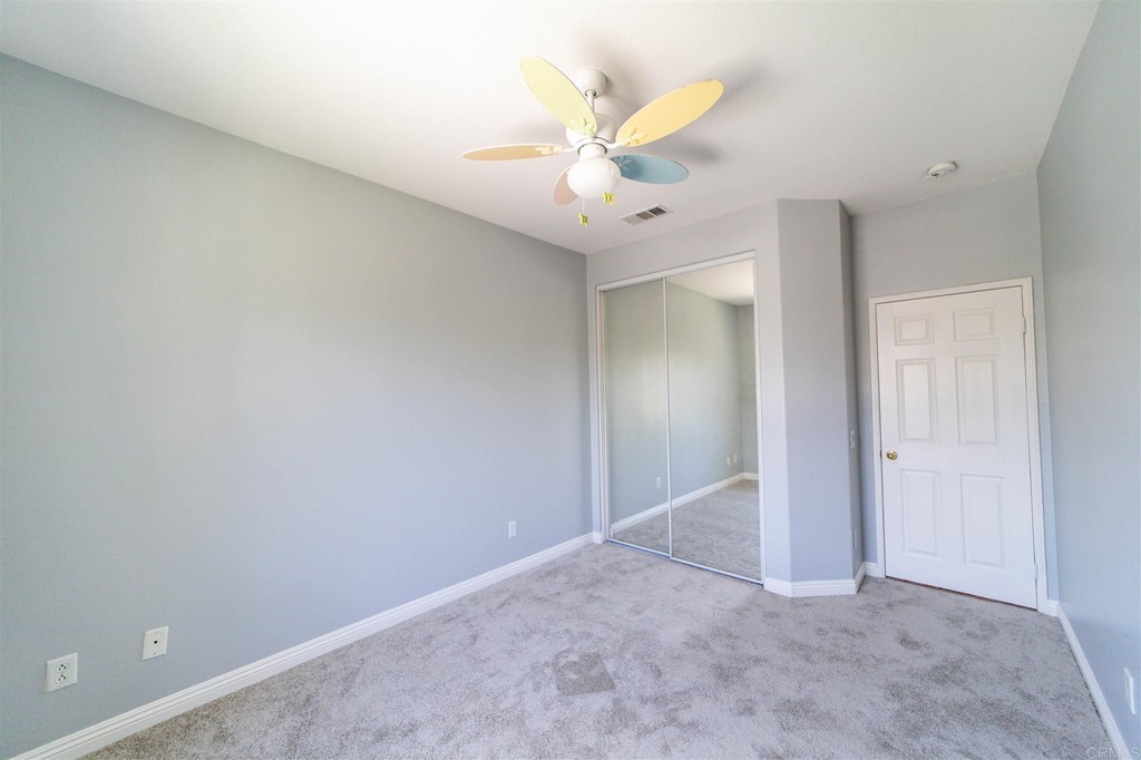 31047 Rose Circle Murrieta, CA 92563 - Photo 12 of 20 an empty room with a ceiling fan and a window