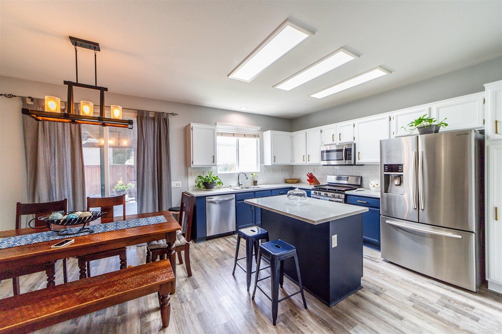 31047 Rose Circle Murrieta, CA 92563 - Photo 5 of 20 a kitchen with stainless steel appliances a dining table chairs stove refrigerator and cabinets