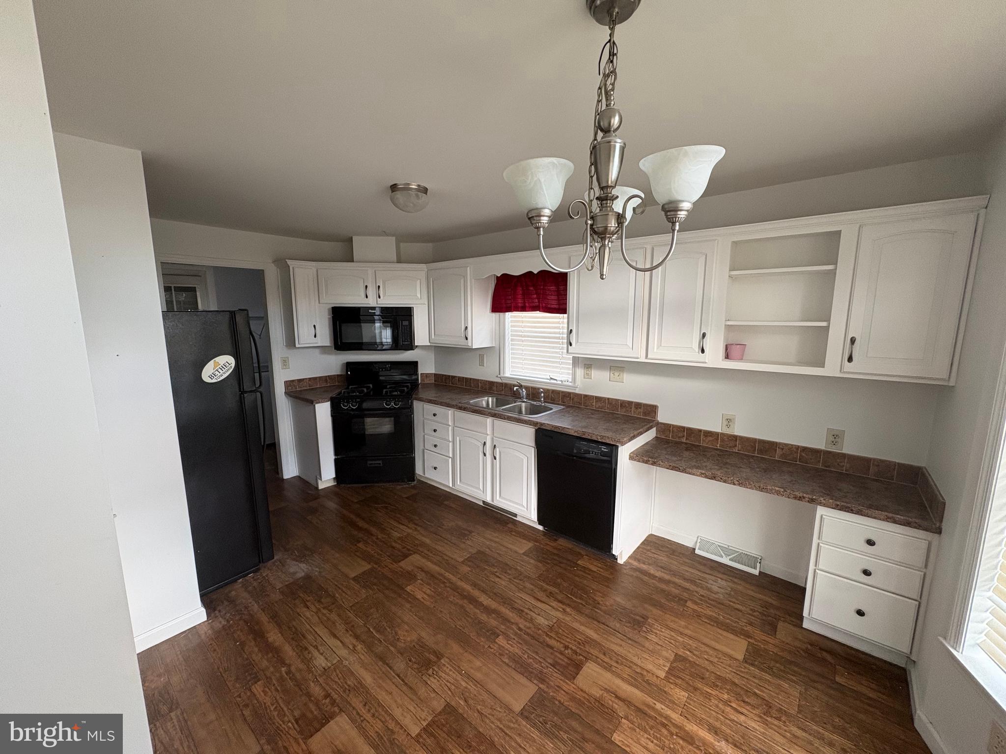 312 Winterset Road Garnet Valley, PA 19060 - Photo 5 of 11 a kitchen with stainless steel appliances granite countertop a refrigerator a sink dishwasher a stove and white cabinets with wooden floor