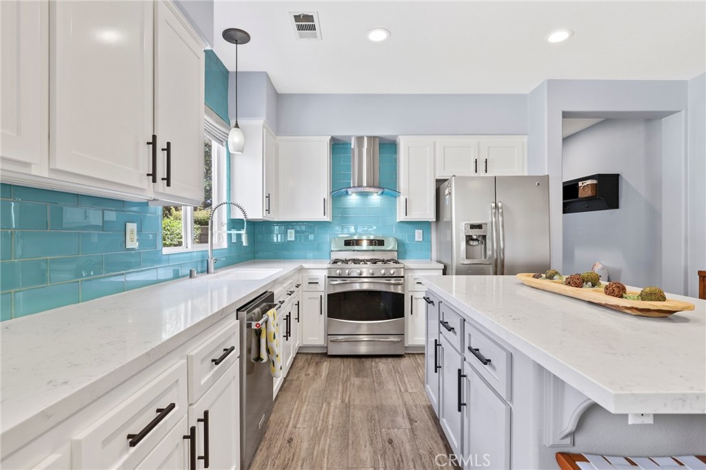 19735 Edmonds Place Saugus, CA 91350 - Photo 4 of 34 a kitchen with a stove sink and cabinets