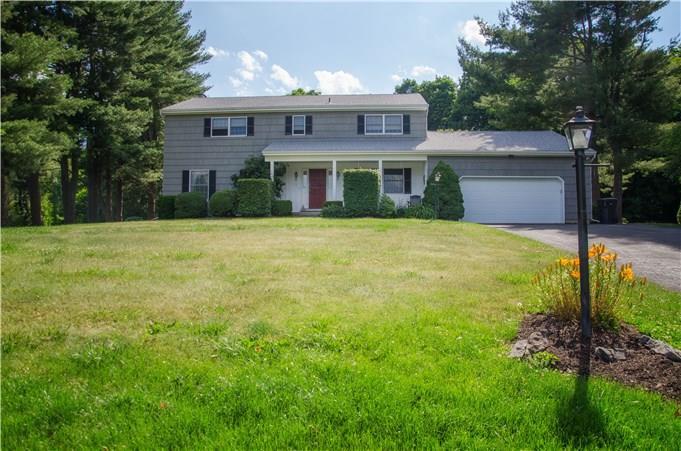 a view of a big house with a big yard and large trees