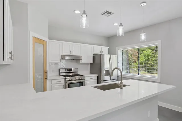 a kitchen with a sink stainless steel appliances and refrigerator