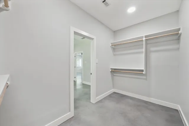 an empty room with closet and a ceiling fan