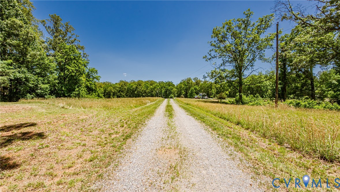 15611 Robert Terrell Road Montpelier, VA 23192 - Photo 28 of 28 Gravel driveway extending through a grassy field,