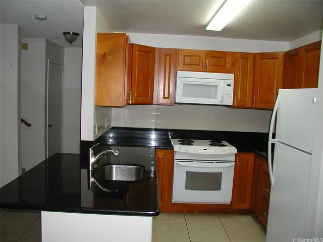 a kitchen with granite countertop a stove and a refrigerator