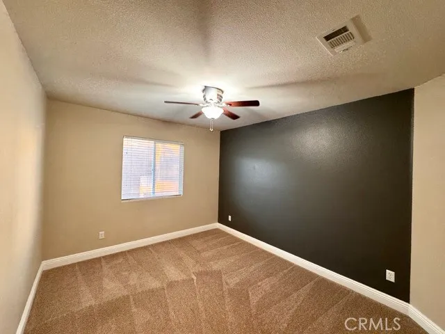 an empty room with closet and a chandelier fan