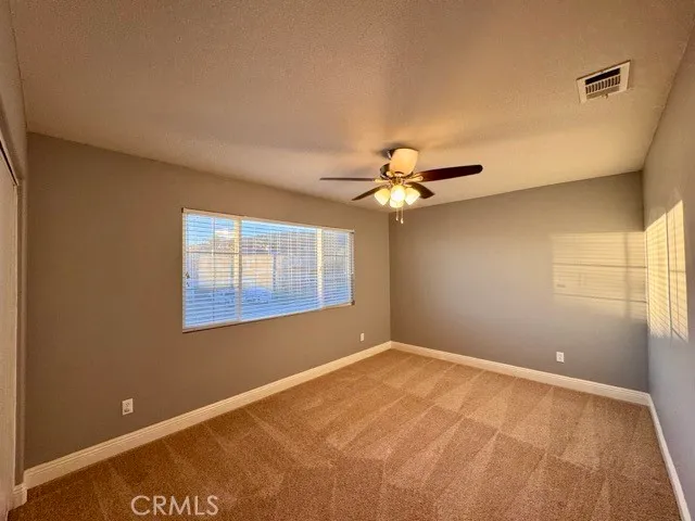a view of a livingroom with a ceiling fan and window