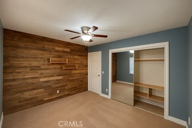 a view of an empty room and a chandelier fan