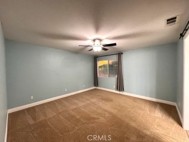 a view of a livingroom with a ceiling fan and window