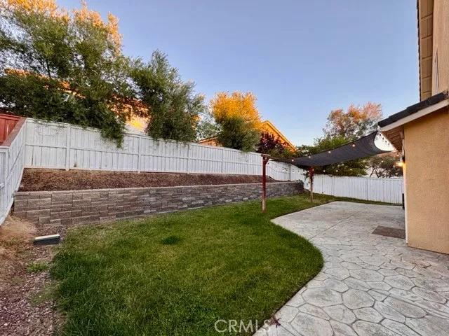a view of a house with backyard and a tree