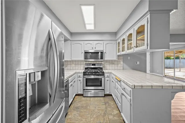 a kitchen with stainless steel appliances granite countertop a stove a refrigerator and a stove