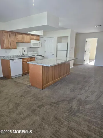 a large kitchen with kitchen island granite countertop a sink and a granite counter tops