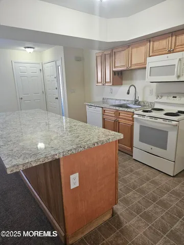 a kitchen with stainless steel appliances granite countertop a sink a stove and a refrigerator