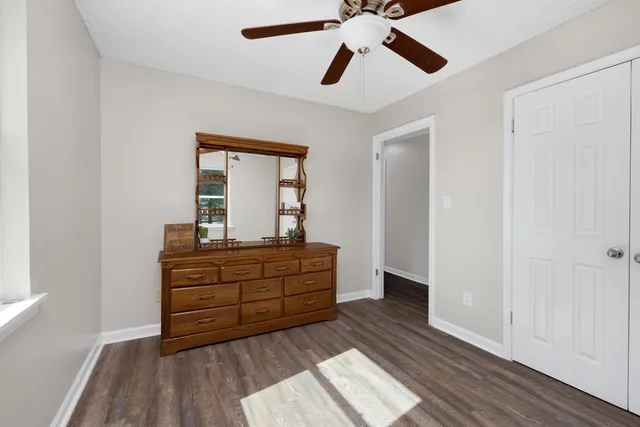 a room with wooden floor and ceiling fan