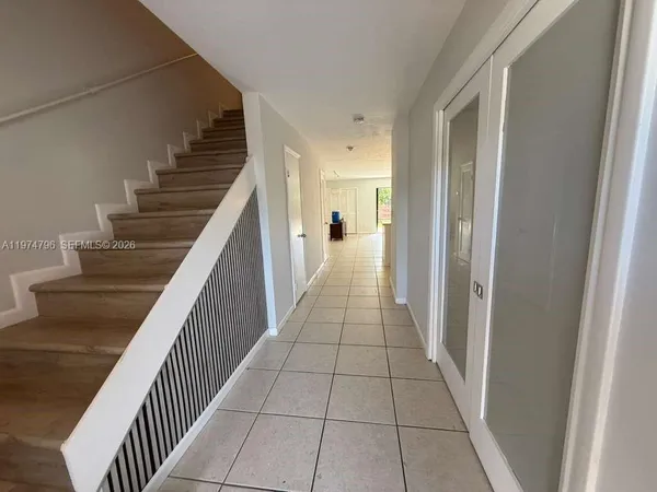 a view of a hallway with wooden floor and stairs
