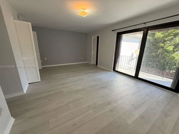 an empty room with wooden floor and door