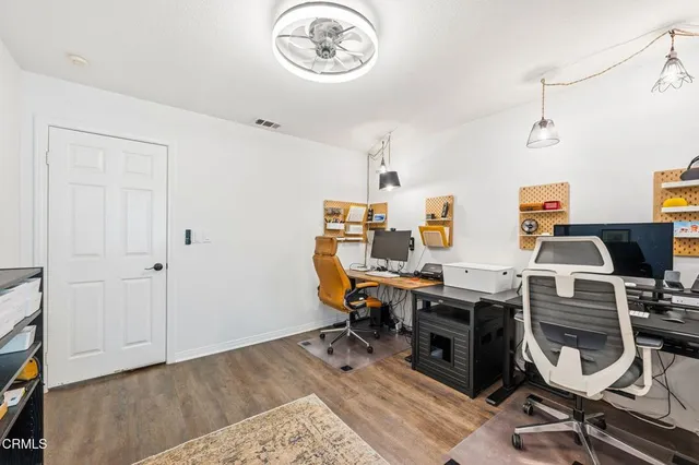 a view of a workspace with furniture and wooden floor