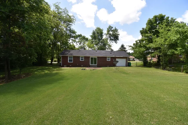 a house that has a big yard with large trees