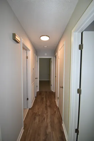 a view of a hallway with wooden floor and closet