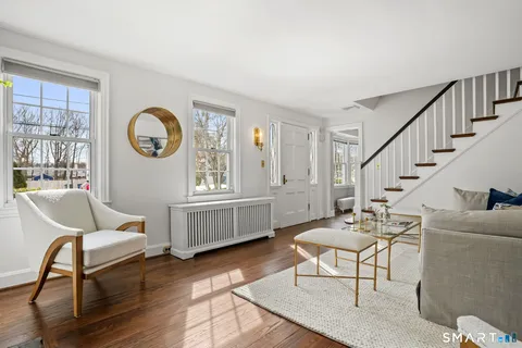 a living room with furniture a clock and a window