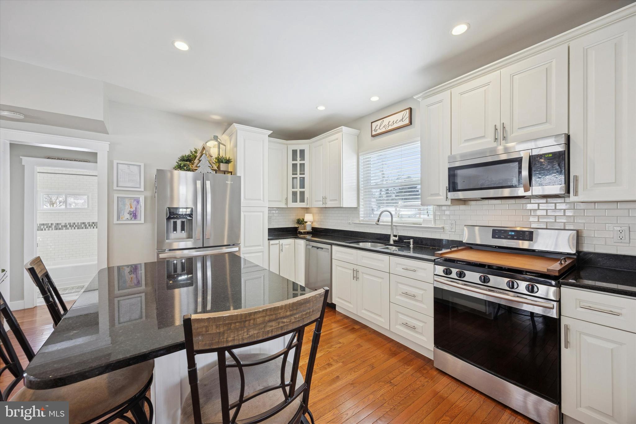 55 Kenton Avenue Pitman, NJ 08071 - Photo 7 of 26 a kitchen with stainless steel appliances granite countertop a stove a sink dishwasher a microwave oven with granite countertops and cabinets