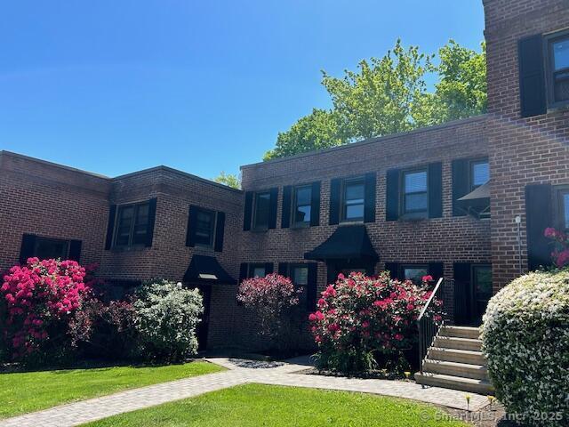 34 Prospect Street, Unit 4M Norwalk, CT 06850 - Photo 2 of 7 a front view of house and yard with beautiful flowers and green space