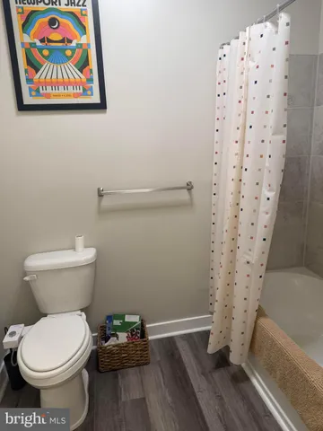 a bathroom with a toilet and a shower curtain
