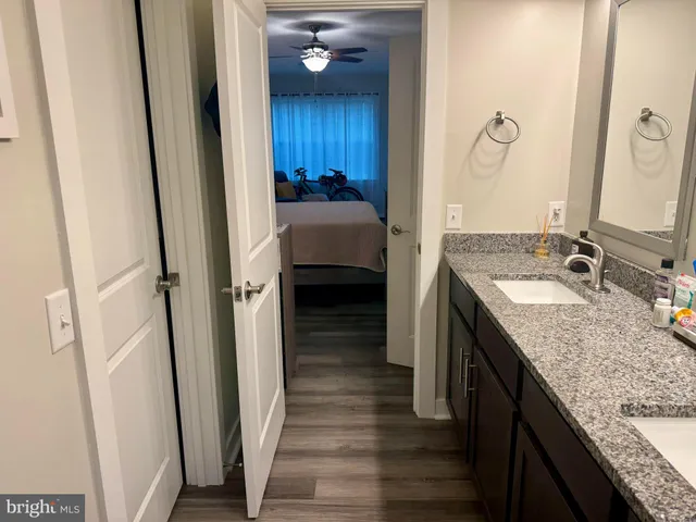 a en suite bathroom with a granite countertop sink and a mirror