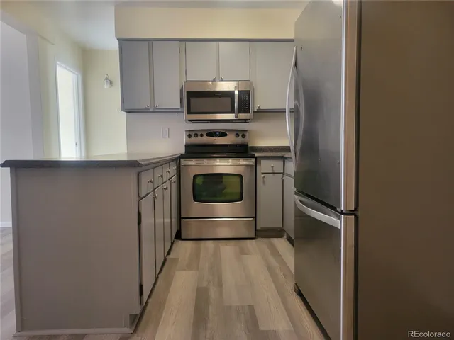 a kitchen with stainless steel appliances a stove a microwave and sink