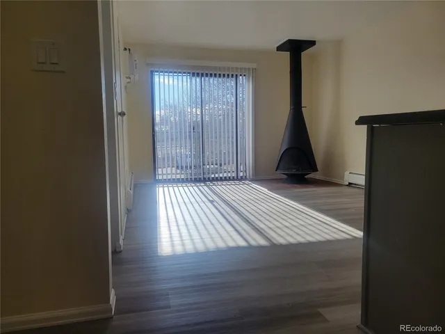 a view of empty room with a window and wooden floor
