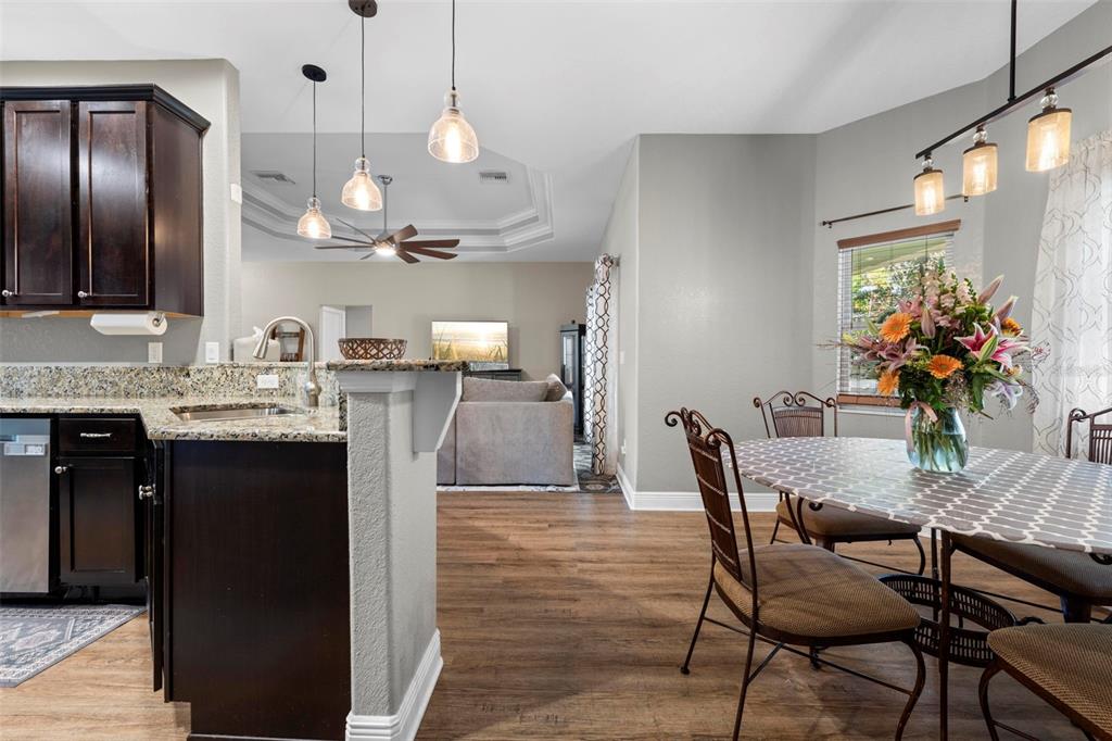 8104 Nightingale Road Weeki Wachee, FL 34613 - Photo 18 of 45 a kitchen with granite countertop a table chairs stove and refrigerator