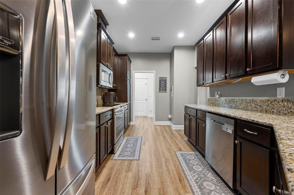 8104 Nightingale Road Weeki Wachee, FL 34613 - Photo 20 of 45 an empty room with wooden floor and stainless steel appliances