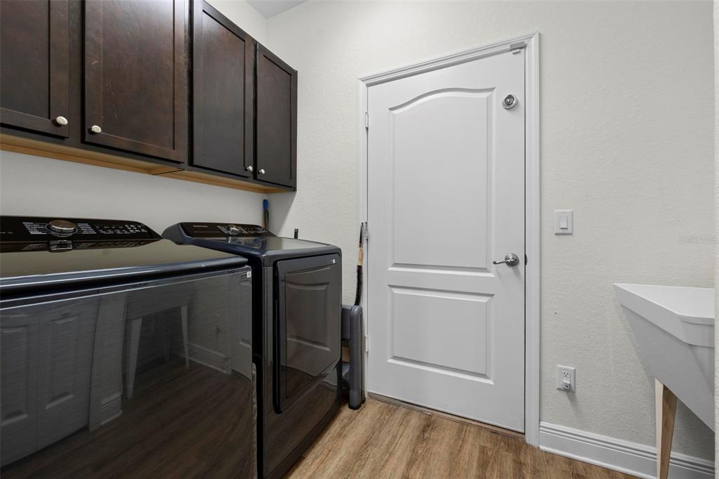 8104 Nightingale Road Weeki Wachee, FL 34613 - Photo 25 of 45 a utility room with wooden floor washer and dryer