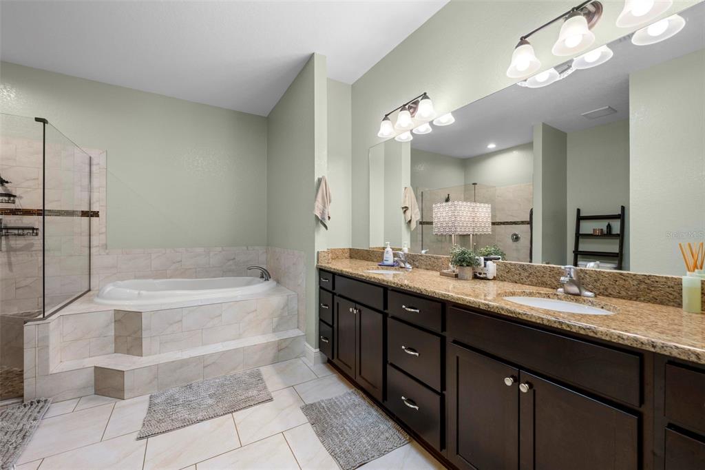 8104 Nightingale Road Weeki Wachee, FL 34613 - Photo 31 of 45 a bathroom with a tub a double vanity sink and a mirror