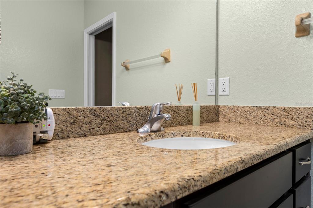 8104 Nightingale Road Weeki Wachee, FL 34613 - Photo 32 of 45 a bathroom with a granite countertop sink and a mirror