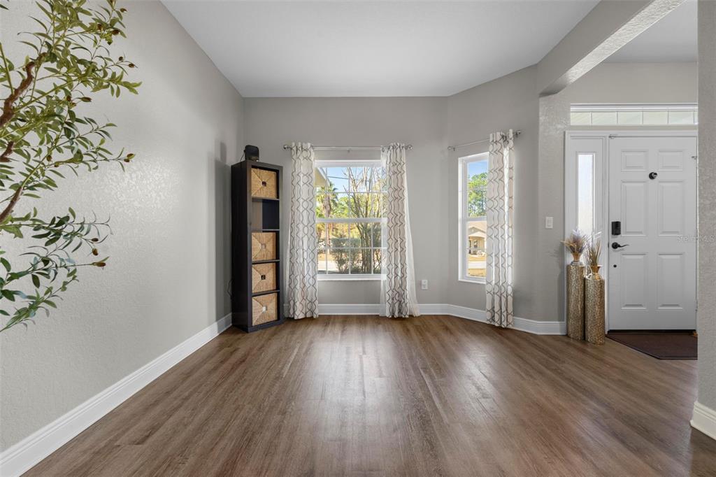 8104 Nightingale Road Weeki Wachee, FL 34613 - Photo 8 of 45 a view of an empty room with wooden floor and a window
