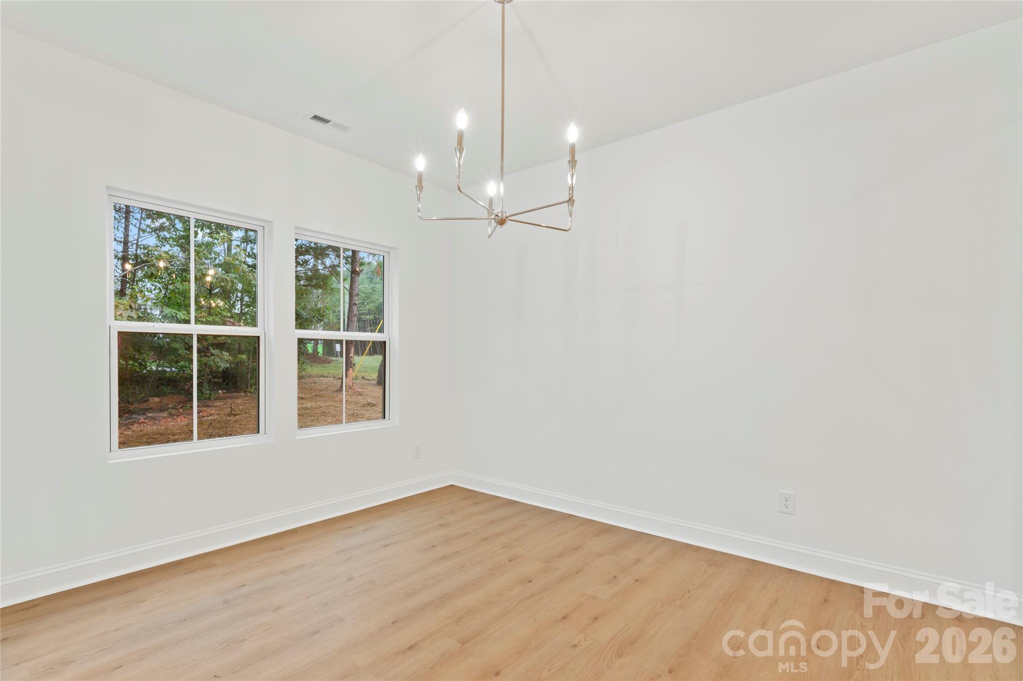 192 Doolie Road Mooresville, NC 28117 - Photo 11 of 36 an empty room with wooden floor and windows