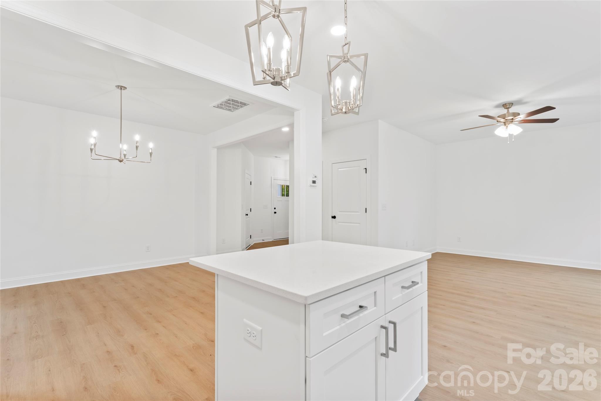 192 Doolie Road Mooresville, NC 28117 - Photo 18 of 36 an empty room with a chandelier fan and wooden floor