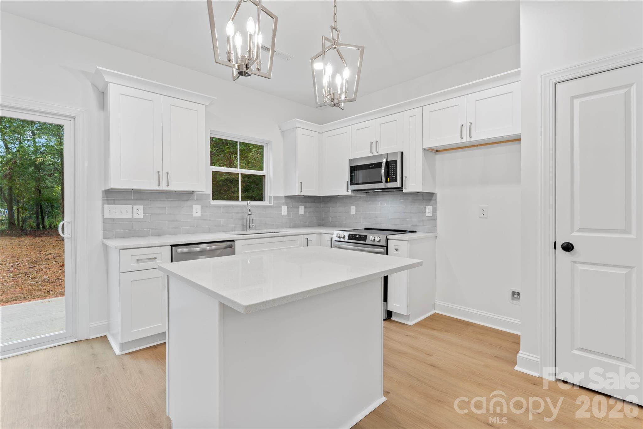 192 Doolie Road Mooresville, NC 28117 - Photo 20 of 36 a kitchen with kitchen island white cabinets and stainless steel appliances