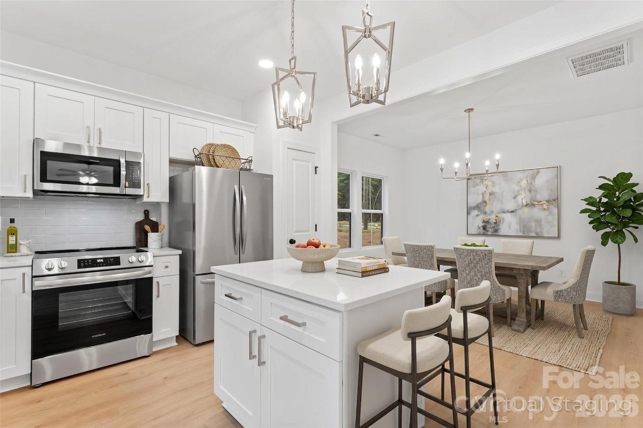 192 Doolie Road Mooresville, NC 28117 - Photo 3 of 36 a kitchen that has a table chairs stainless steel appliances and cabinets