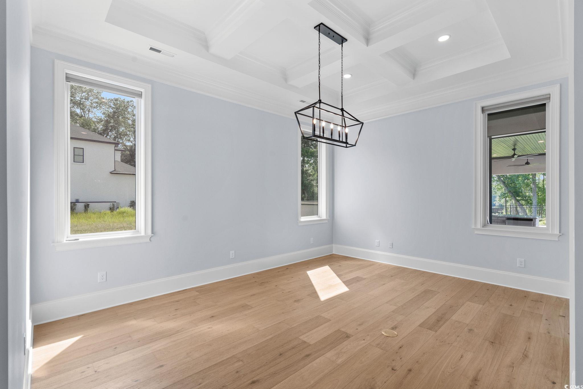 372 Chamberlin Road Myrtle Beach, SC 29588 - Photo 20 of 39 Empty room featuring coffered ceiling, a chandelie