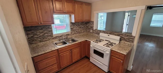 a kitchen with stainless steel appliances granite countertop a stove a sink and a microwave